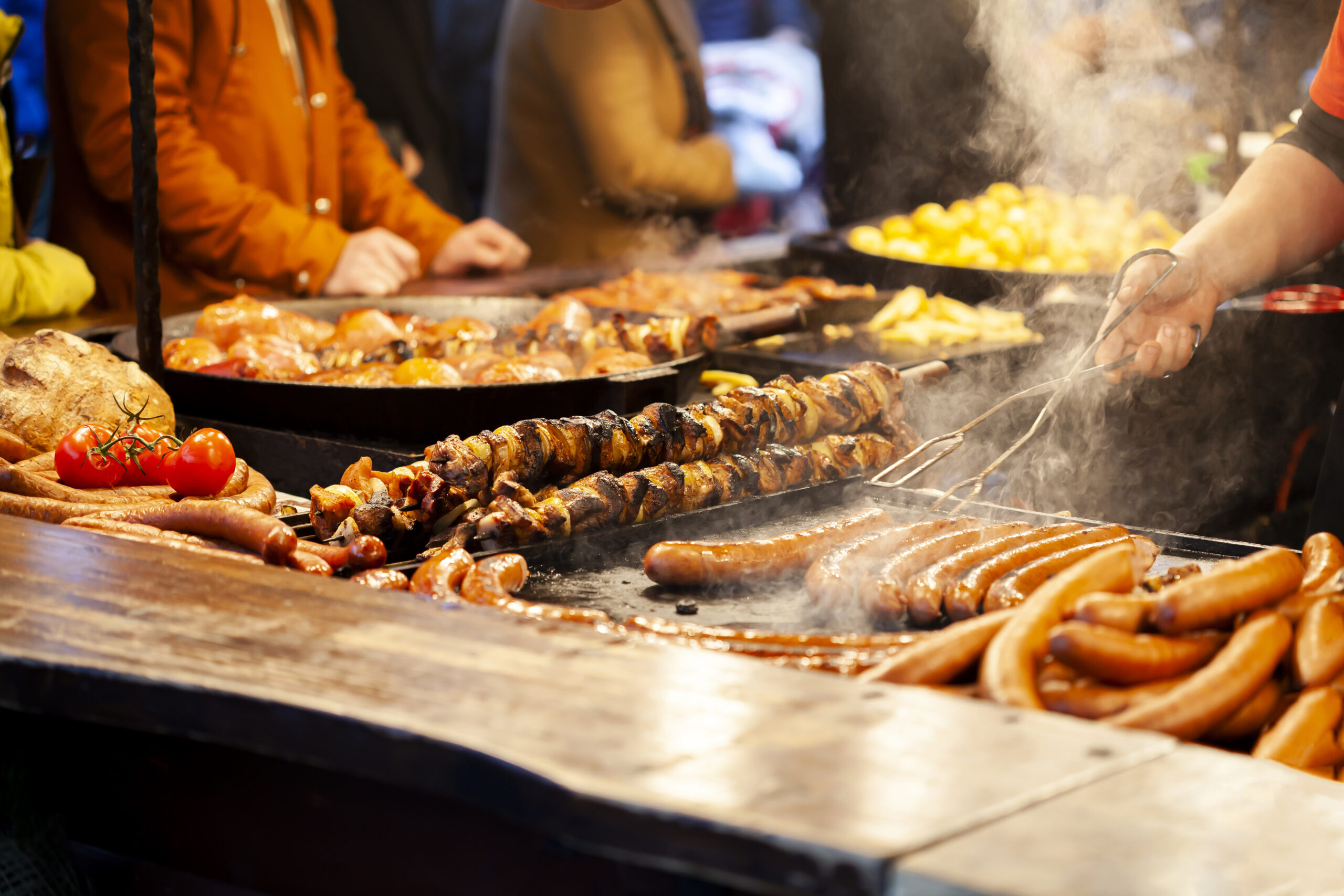 Krakow, Polen, gesunder traditioneller Straßenimbiss, Gruppe anonymer Menschen, Stadtleben, Lifestyle, Rauch über Essen, Fleisch, Tischdecke, Hände mit Metallflip-Flops. Grill, Outdoor-Grill, Altstadt