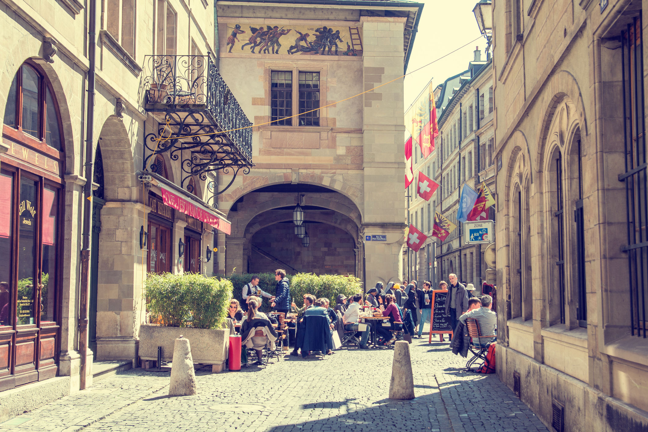Geneva, Switzerland - April 10, 2015: Old buildings and restaurant full of people in Gevena Old Town during weekend
