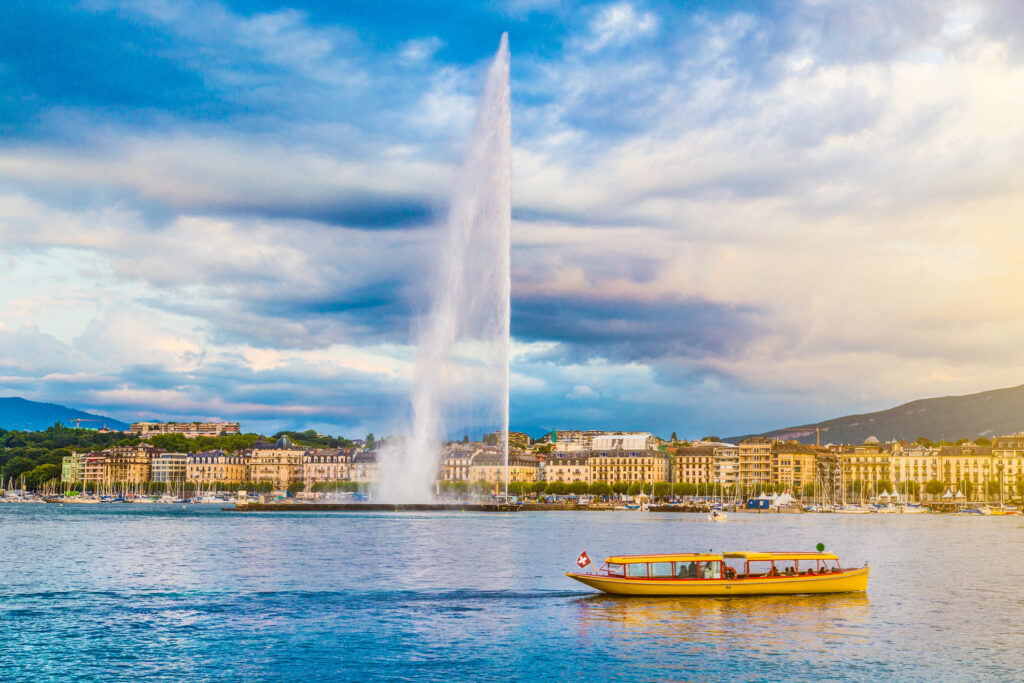 Beautiful view of Geneva skyline with famous Jet d'Eau fountain at harbor district in beautiful evening light, Switzerland.